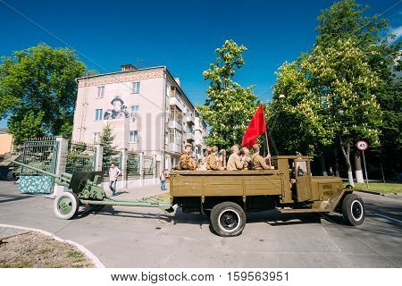 Gomel, Belarus  - May 9, 2016: Russian Soviet Military Truck ZIS-5V With Men In Soldiers Uniform On Board, Weapon, Red Flag Of WW2, Towing ZiS-2 57-Mm Anti-Tank Gun. Prepare For 9 May Victory Parade
