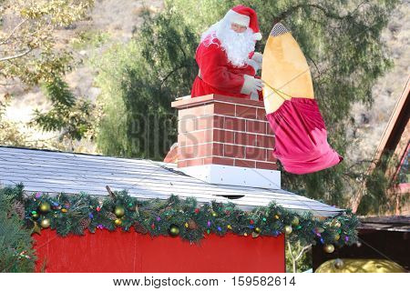 Santa Claus enters a home through the Chimney bringing his bag of toys and gifts for all the good boys and girls.