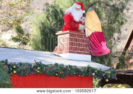 Santa Claus enters a home through the Chimney bringing his bag of toys and gifts for all the good boys and girls.