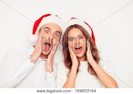 Wow! Portrait Of Two Shocked Amased Excited Lovers In Red  Santa Hats