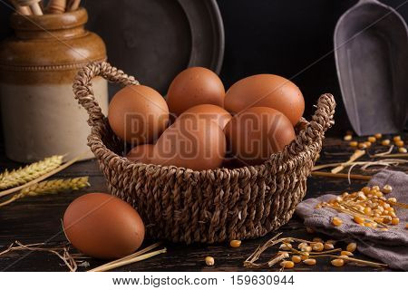 Free range eggs in a basket with corn and straw.