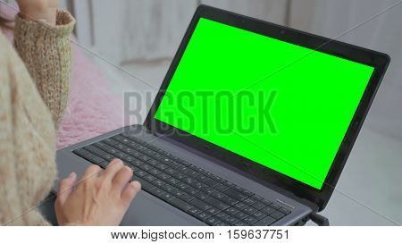 Woman using laptop with green screen. Business, communication, freelance and internet concept