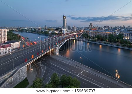 Big Bridge Krasnokholmsky with flags, river, evening quay in Moscow, Russia