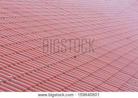 Pattern of a red tile roof of plastic plates.