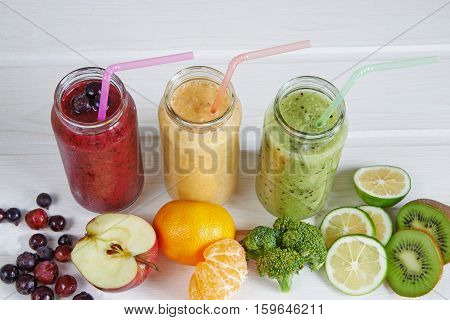Smoothies of kiwi, mandarin, banana, Lemon, apple, currants, berries on a white background