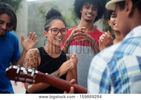 Young people listening to a concert of a muscian