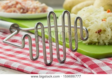 Potato Masher And Ingredients For Typical Dutch Dish Zuurkool