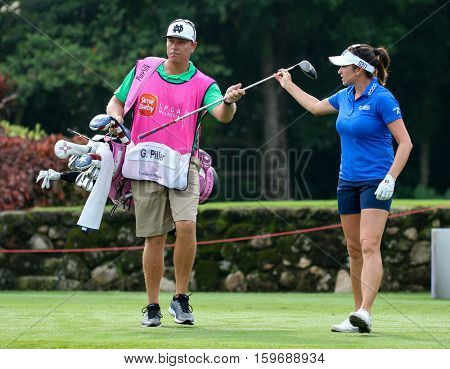 KUALA LUMPUR, MALAYSIA - OCTOBER 29, 2016: Gerina Piller of the USA checks with her caddie on the fairway of the TPC Golf Course at the 2016 Sime Darby LPGA Malaysia golf tournament.