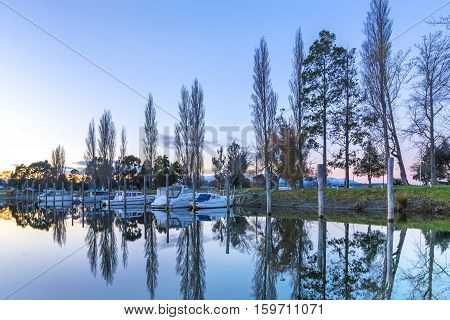 A row of boats with reflection during sunrise moment