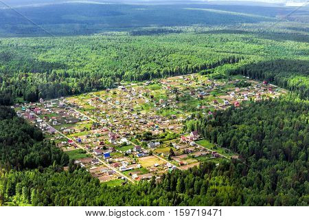 The cozy little village in the middle of the taiga forest. Airview
