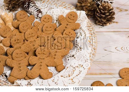 Christmas smiling gingerbread men men and women on white handmade lace with Christmas decoration