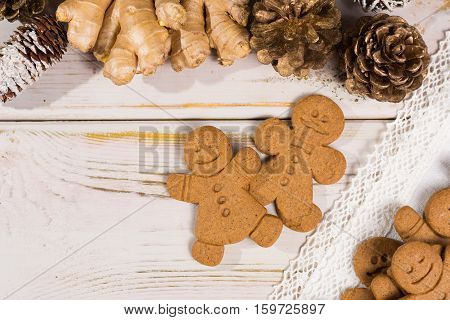 Christmas smiling gingerbread men men and women on white handmade lace with Christmas decoration