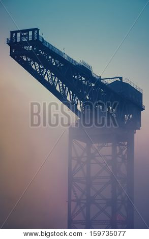 Retro Vintage Industrial Shipbuilding Crane In Glasgow Scotland In The Fog At Sunrise