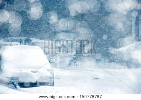 parked cars covered with snow during snowing in winter time
