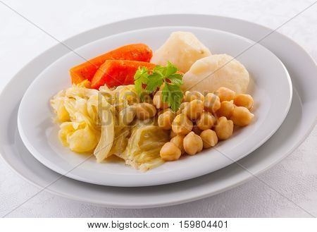 Cocido Madrileño is a delicious Spanish stew with chickpeas sausages potatoes cabbage and various types of meat.