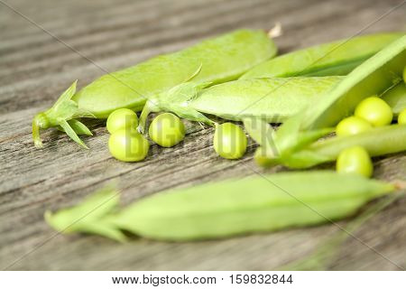 Green fresh peas in a pod. Organic food. Wooden rustic background. healthy seasoning food. Selective focus.