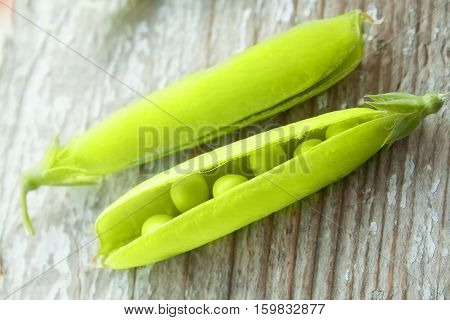Green fresh peas in a pod. Organic food. Wooden rustic background. healthy seasoning food. Selective focus.