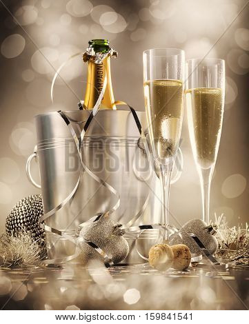 Two glasses of champagne with bottle in cooler in the background selective focus