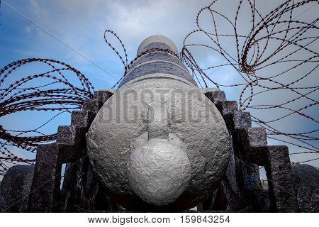 Old cannon aiming to the sky with razor wire