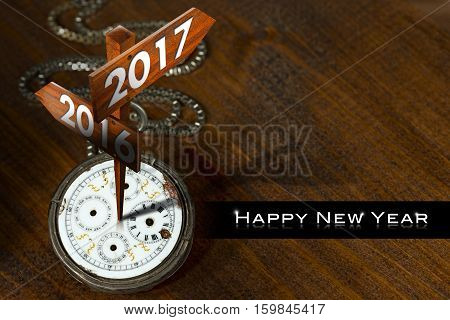 Happy New Year 2017 - Old pocket watch with two wooden signs with arrows and the years 2016 and 2017
