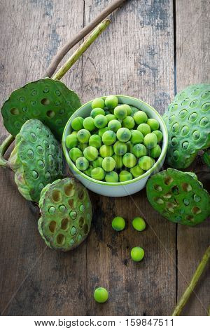 Lotus Seeds In White Bowl And Calyx On Wood Background