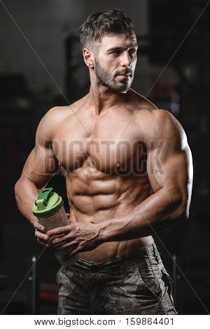 Handsome Athletic Fitness Man Holding A Shaker And Posing Gym