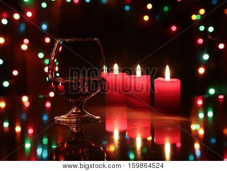 christmas composition photo cognac glass and candle on black background.
