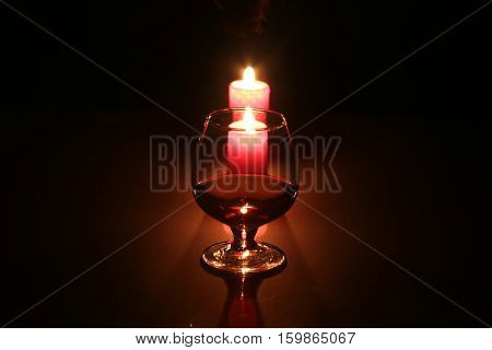 christmas composition photo cognac glass and candle on black background.