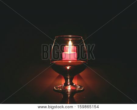 christmas composition photo cognac glass and candle on black background.