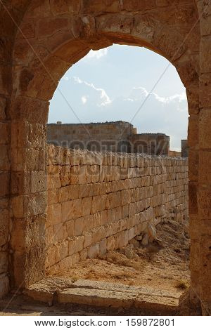 Ancient stone arch and wall at sunset
