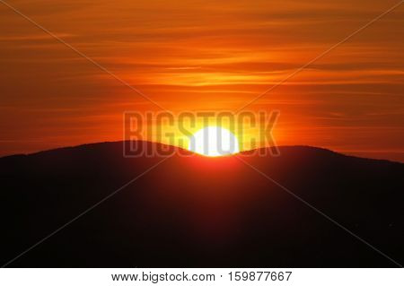 Orange sunset behind the mountains. Quebec, Canada.