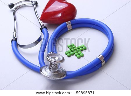 Red heart and a stethoscope on desc.