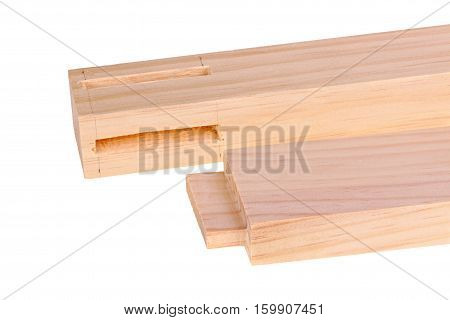 Close-up of the ends of pine boards with two freshly cut woodworking mortises and a tenon isolated against a white background