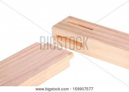 Close-up of the ends of pine boards with two freshly cut woodworking mortises and a tenon isolated against a white background