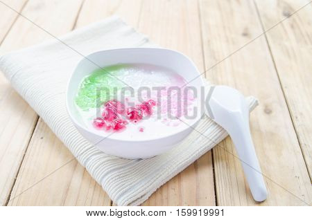 Tub Tim Krob ,Stuffed Water Chestnut in Syrup and Coconut Milk on wood table thailand dessert.