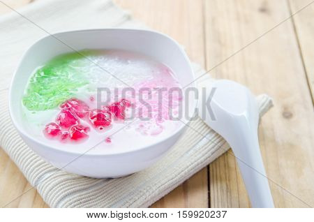 Tub Tim Krob ,Stuffed Water Chestnut in Syrup and Coconut Milk on wood table thailand dessert.