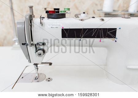 Sewing machine with colorful needles side view. Professional equipment of seamstress. Tailor workshop, garment factory, clothes making industry concept