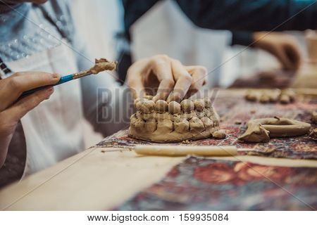 children's hands sculpts clay crafts pottery school
