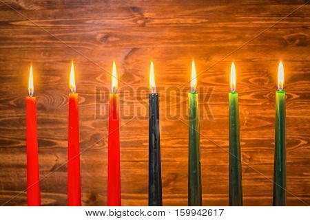 Kwanzaa Festival Concept With Seven Candles Red, Black And Green On Wooden Background, Close Up