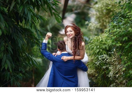 Wedding. Young happy bride and groom together in garden. Marriage concept