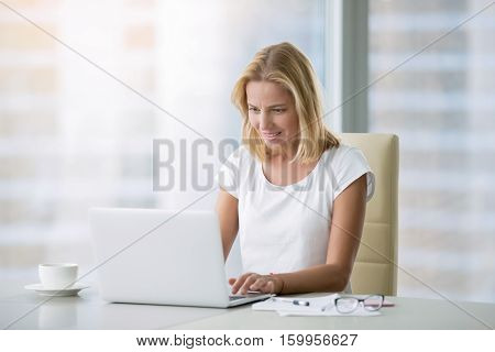 Young attractive woman at a modern office desk, working with laptop, free online classes for interest, stay-at-home mom starting an online business, internet marketing, remote job, lady- blogger