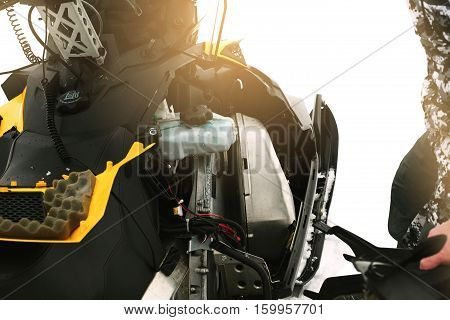 Driver repairing a broken snowmobile. Winter sports.