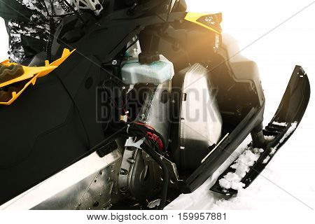 Driver repairing a broken snowmobile. Winter sports.