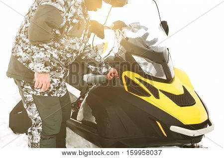 Driver repairing a broken snowmobile. Winter sports.