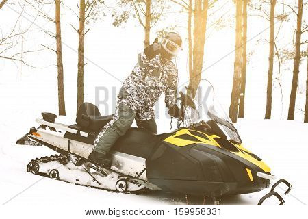 The sportsman on a snowmobile. Recreation concept on nature in winter and New Year holidays. Winter sports.