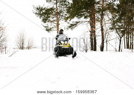 The sportsman on a snowmobile. Recreation concept on nature in winter and New Year holidays. Winter sports.