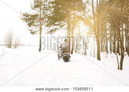 The sportsman on a snowmobile. Recreation concept on nature in winter and New Year holidays. Winter sports.