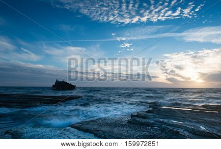 Shipwreck of an abandoned ship on a rocky coast at Akrotiri Beach in Cyprus
