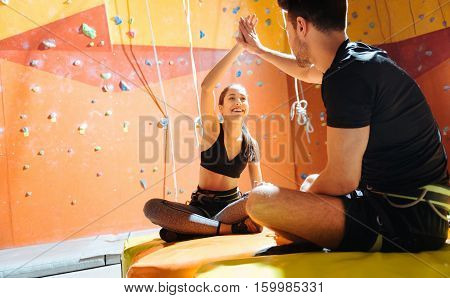 Happy life. Smiling young active couple sittiing together in a climbing gym after training.and enjoying their hobby.