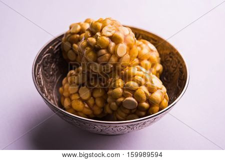 Putnala / futana  / Dalia / Roasted Chickpeas sweet Laddu made up of jaggery or gud or gur in hindi, selective focus
